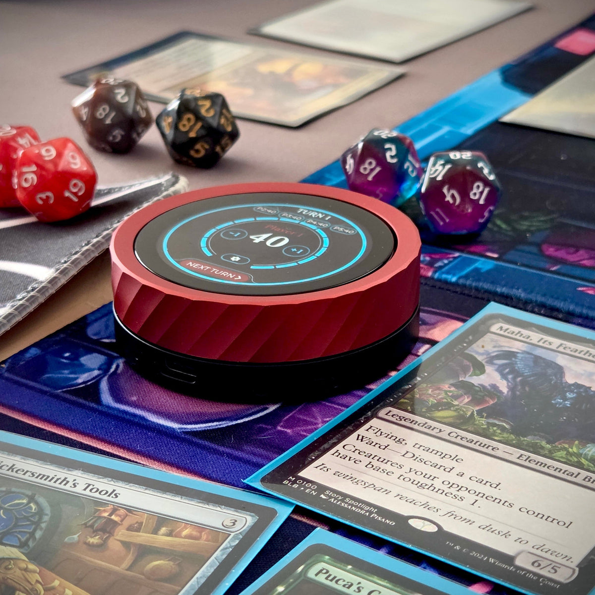 Red and black digital device on a table with board game cards and dice